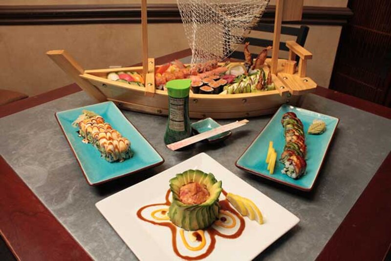 Tuna tartar appetizer, sushi boat and two plated sushi rolls
