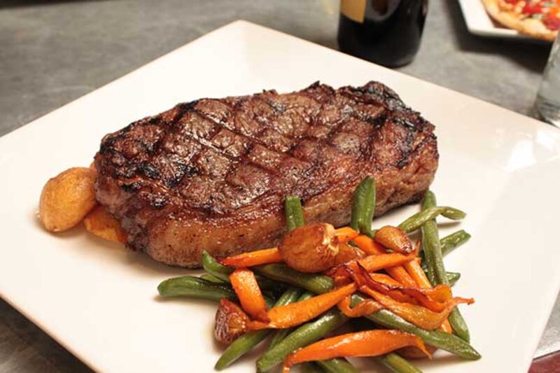 Steak with a side of sauteed vegetables